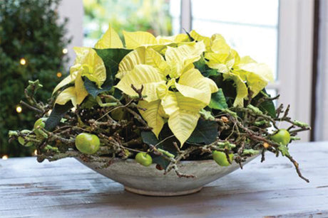 Enkel och stämningsfull juldekoration i naturmaterial med minijulstjärnor (Euphorbia pulcherrima) på fat, mossiga grenar som krans, röda dekorationsäpplen och gröna stjärnor – perfekt för julbordet.