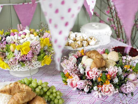 Påskblommor i vårkruka på altan: blomsterarrangemang med tulpaner på lök, minipåskliljor, primula och murgröna – vacker dekoration för trappa och patio, planteras ut efter blomning.