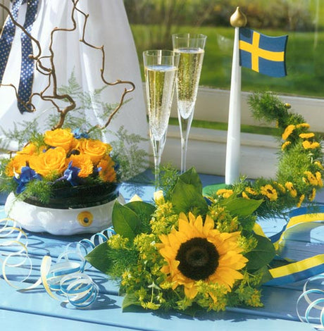 Sverigebuketten med svenskodlade blå och gula blommor i svenska flaggans färger – riddarsporrar, anemoner, rosor och smörbollar – perfekt studentbukett på försommaren; stödjer Kungliga Blomsterstiftelsen och Kronprinsessan Victorias fond