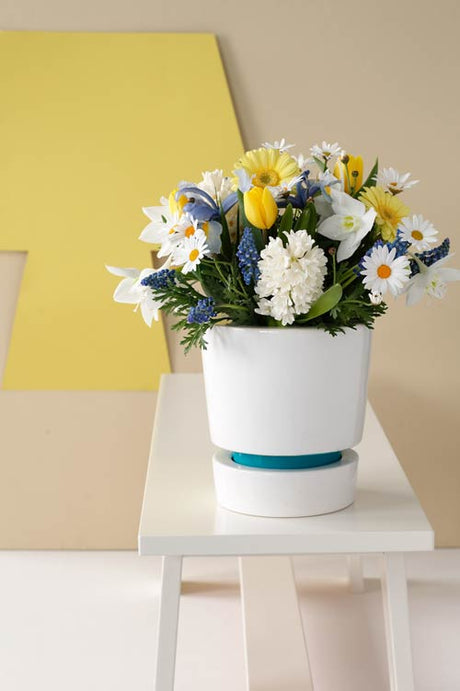 Lekfullt blomarrangemang: bukett med snittblommor – tulpaner, iris och gerbera – i tvåfärgad kombination med vitt, starka kontraster och klara, fräscha färger i modern stil.