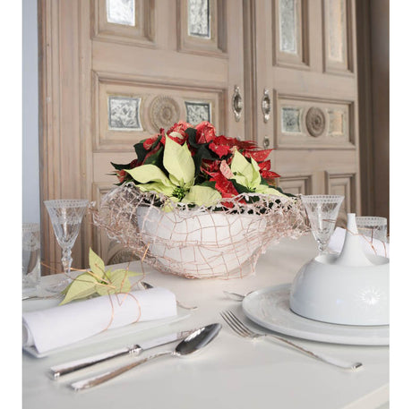 Duka till fest med julstjärnor: långbord i modern stil med rosa och vita julstjärnor i glas och koppardetaljer, minijulstjärna på varje tallrik och servett med koppartråd – inspirerande juldukning.