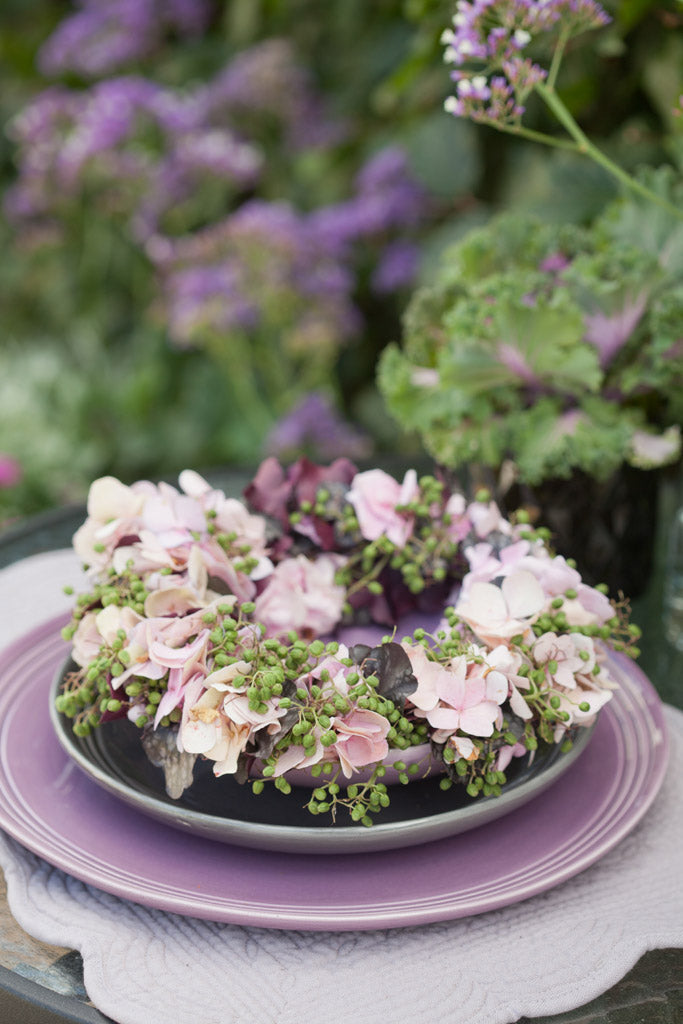 Fläder och hortensiakrans – blomkrans som bordsdekoration; sätt blommor tätt, bunden med bindtråd av grönt och krukväxter för livfullt säsongens blomarrangemang