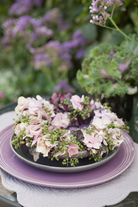 Fläder och hortensiakrans – blomkrans som bordsdekoration; sätt blommor tätt, bunden med bindtråd av grönt och krukväxter för livfullt säsongens blomarrangemang