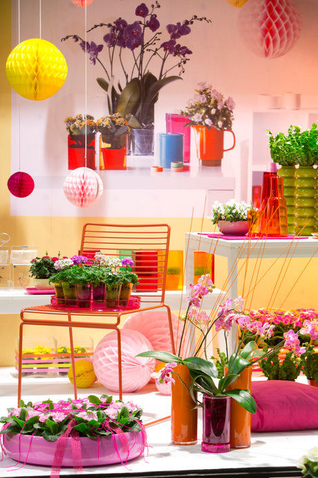Floradania färgstark trend – växter som konst: hortensia, ranunkel, rosor och phalaenopsis i plast, plexi och färgat glas; sorbettoner med neonrosa, gyllene orange, vitt som bas och holografisk ljuslek.