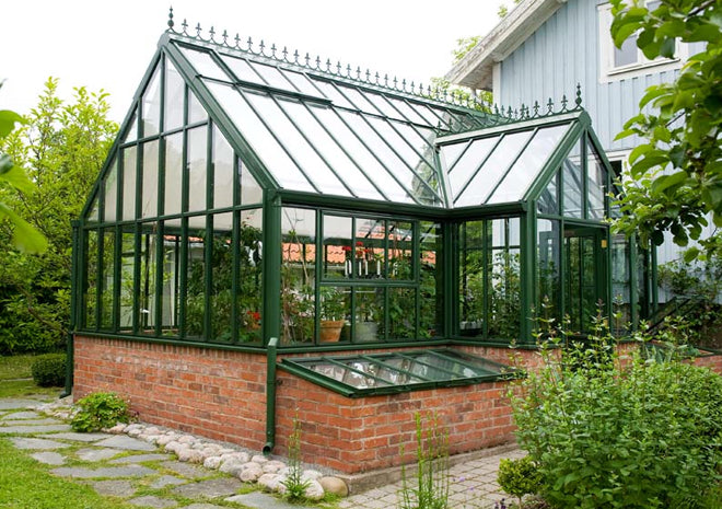 Lean-to växthus Hartley Botanic Victorian Lodge i Billdal, Göteborg – Vansta trädgårds växthusprojekt med Pastorale-tegelgrund, Ruta-tegelgolv, kallbänkar, odlingsbord och skuggardiner.