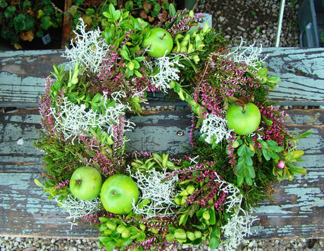 Dörrkrans för vintersäsongen med ljusa, friska färger: mossa, ljung, äpplen, buxbom och silvergirland, inspirerad av Jenny Strandhs blomsterdesign i Oxie.