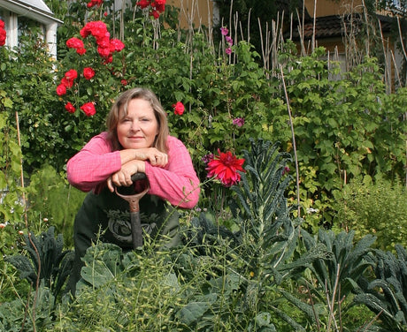 Tyra Hallsénius Lindhe i sin växthus- och kökslandsodling: potager med upphöjda bäddar, återbrukat och luftigt växthus med betonggolv; odling av tomater, chili, aubergine och basilika.